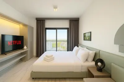 a hotel room with a bed and a tv at Stylish Studio in Meydan 10mins away Burj Khalifa in Dubai