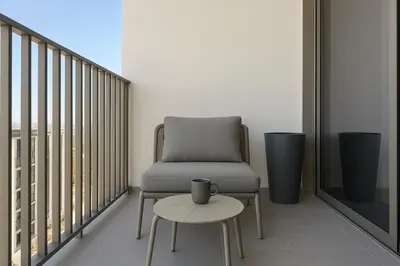 a chair and a table on a balcony at Stylish Studio in Meydan 10mins away Burj Khalifa in Dubai