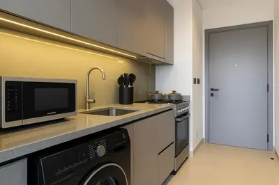 a kitchen with a sink and a microwave at Modern Studio in Meydan - Minutes from Dubai Mall in Dubai
