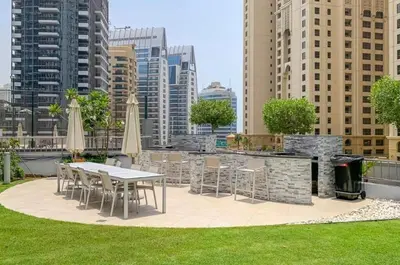a patio with tables and chairs and buildings at Marina Wharf 1 Bedroom with JBR Beach Views in Dubai