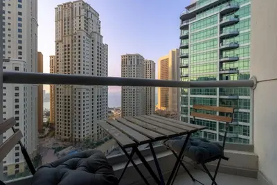 a table on a balcony with a view of a city at Marina Wharf 1 Bedroom with JBR Beach Views in Dubai