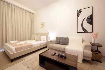 a hotel room with a bed and a couch at Contemporary JVC Studio with Rooftop Pool Gym in Dubai