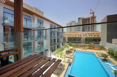 a balcony with a swimming pool in a building at Contemporary JVC Studio with Rooftop Pool Gym in Dubai