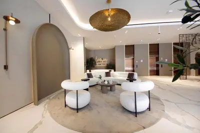 a living room with white chairs and a couch at Contemporary JVC Studio with Rooftop Pool Gym in Dubai