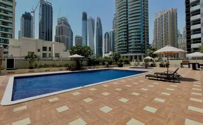 a swimming pool in a city with tall buildings at Apartment Close to Metro in Dubai Marina in Dubai
