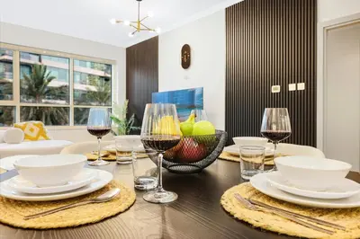 a dining room table with glasses of wine at Luxury 1BR Dubai Marina Apartment Walk to JBR Beach & Marina Yacht Club in Dubai