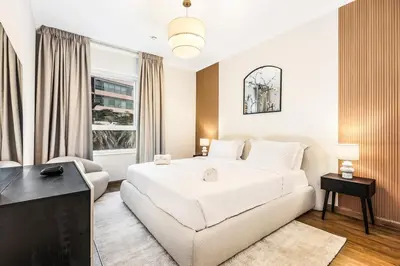 a bedroom with a large white bed and a couch at Luxury 1BR Dubai Marina Apartment Walk to JBR Beach & Marina Yacht Club in Dubai