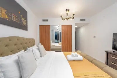 a bedroom with a large white bed and a television at Duplex Penthouse on 73rd Floor in Dubai Marina in Dubai