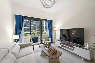 a living room with a couch and a large television at Stylish 1BR near Business Bay, Meydan Racecourse & Crystal Lagoon in Dubai