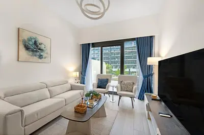 a living room with a couch and a tv at Stylish 1BR near Business Bay, Meydan Racecourse & Crystal Lagoon in Dubai