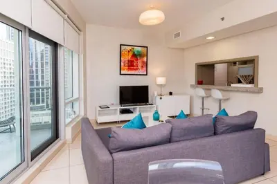 a living room with a couch and a tv at The Lofts, Burj Khalifa View in Dubai