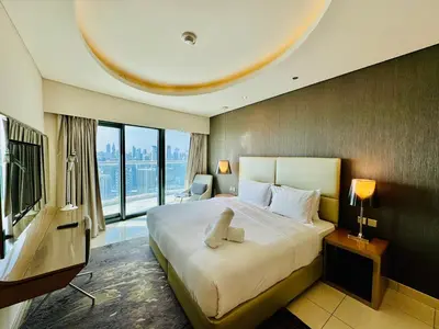 a hotel room with a large bed and a large window at Luxe 3BR , Paramount by DAMAC, Excellent Pool in Dubai