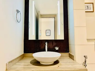 a bathroom with a large white bowl sink on a wooden floor at Luxe 3BR , Paramount by DAMAC, Excellent Pool in Dubai