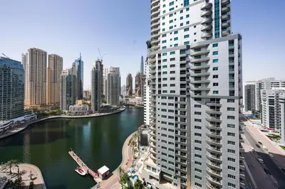 a tall building next to a river in a city at Best View in Marina Dubai in Dubai