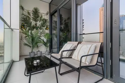a balcony with two chairs and a table at FIRST CLASS 1BR Contemporary Comfort in Dubai