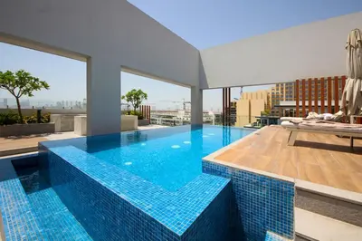 a large swimming pool with blue tiles on a building at Modern Loft Studio JVC ,Stylish & Fully Furnished in Dubai
