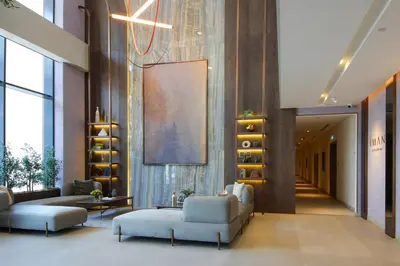a lobby with couches and chairs in a building at Modern Loft Studio JVC ,Stylish & Fully Furnished in Dubai