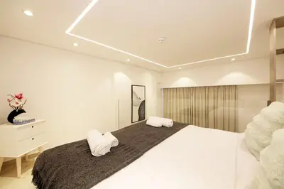 a bedroom with a large bed with two towels at Modern Loft Studio JVC ,Stylish & Fully Furnished in Dubai