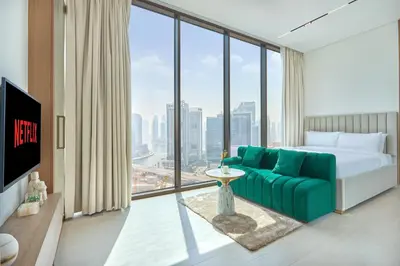 a hotel room with a bed and a large window at Charming Studio with Scenic Canal Views in Dubai