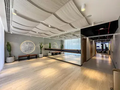 a large room with a wooden floor and a large ceiling at Bright Studio in JVC with Pool and Gym Access in Dubai