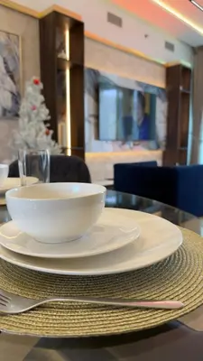 a table with two white bowls on top of it at Highend Azure 1BR Sea View and Private Beach with Pool Access in Dubai
