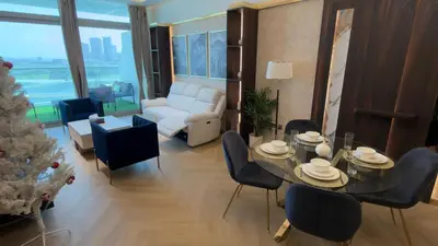 a living room with a christmas tree and a table and chairs at Highend Azure 1BR Sea View and Private Beach with Pool Access in Dubai