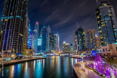 a city skyline at night with a river and buildings at Silk Valley - Cozy Studio steps away from the Beach and Marina in Dubai