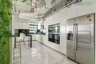 a kitchen with white walls and stainless steel appliances at Luxe 3-Bedroom Sky Retreat in Dubai Marina in Dubai