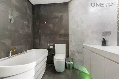 a bathroom with a tub and a toilet and a sink at Luxe 3-Bedroom Sky Retreat in Dubai Marina in Dubai