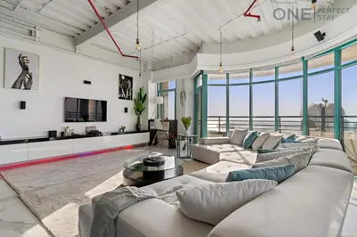 a living room with a large couch and a table at Luxe 3-Bedroom Sky Retreat in Dubai Marina in Dubai