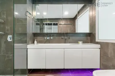 a bathroom with a white sink and a mirror at Luxe 3-Bedroom Sky Retreat in Dubai Marina in Dubai