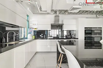 a white kitchen with white cabinets and appliances at Luxe 3-Bedroom Sky Retreat in Dubai Marina in Dubai