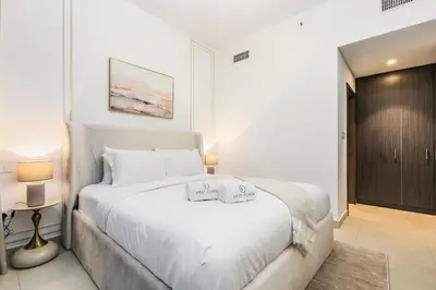 a white bedroom with a large white bed in it at FIRST CLASS 1BR Stylish Gem Near Dubai Mall in Dubai