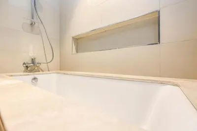 a white bath tub in a bathroom with a window at FIRST CLASS 1BR Stylish Gem Near Dubai Mall in Dubai