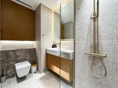 a bathroom with a shower and a sink and a toilet at Dubai Studio with Balcony, Canal Views Pool Access in Dubai