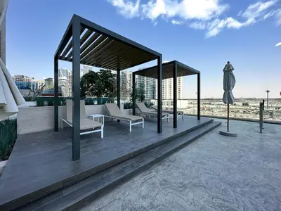 a pavilion with chairs and an umbrella on a roof at Dubai Studio with Balcony, Canal Views Pool Access in Dubai