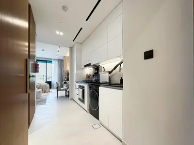 a kitchen with white cabinets and a stove at Dubai Studio with Balcony, Canal Views Pool Access in Dubai