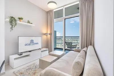 a living room with a couch and a tv at Contemporary 1BR Home in Damac Hills in Dubai