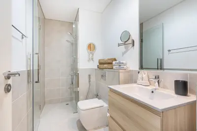 a bathroom with a toilet and a sink and a shower at Contemporary 1BR Home in Damac Hills in Dubai