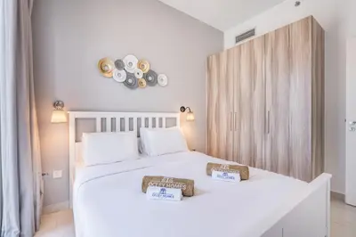 a bedroom with a white bed with two baskets on it at Contemporary 1BR Home in Damac Hills in Dubai