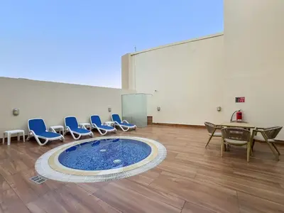 a room with chairs and a table and a pool at FIRST CLASS 2BR Cozy City Retreat in Dubai