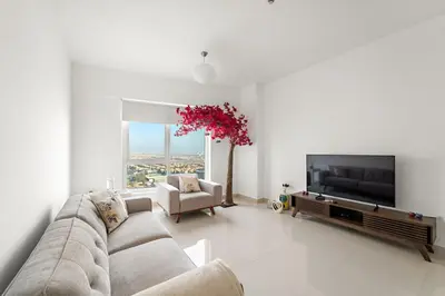 a living room with a couch and a flat screen tv at FIRST CLASS 2BR Cozy City Retreat in Dubai