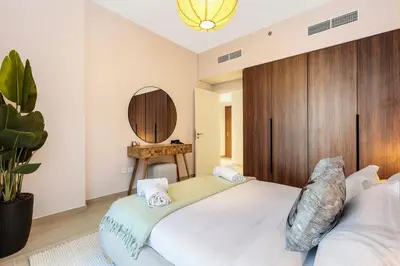 a bedroom with a large bed and a mirror at FIRST CLASS 1BR Classic Luxe Getaway in Dubai