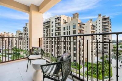 a balcony with chairs and a view of buildings at FIRST CLASS 1BR Classic Luxe Getaway in Dubai
