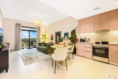 a kitchen and living room with a table and a couch at FIRST CLASS 1BR Classic Luxe Getaway in Dubai