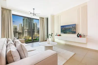 a living room with a white couch and a large window at Stylish 2BR Downtown Dubai with Skyline & Burj Khalifa Views in Dubai