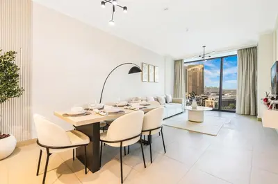 a dining room and living room with a table and chairs at Stylish 2BR Downtown Dubai with Skyline & Burj Khalifa Views in Dubai