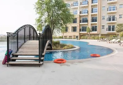 a playground with a slide and orange frisbees next to a building at FIRST CLASS Studio Elegant Escape, Cozy Luxe in Dubai
