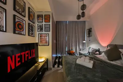a bedroom with a bed and a tv and a couch at Elite Escapes - Boy Girl Apartment Edition in Dubai