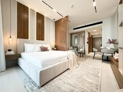 a bedroom with a large bed and a living room at Peaceful Studio Stay Canal Views Poolside Comfort in Dubai